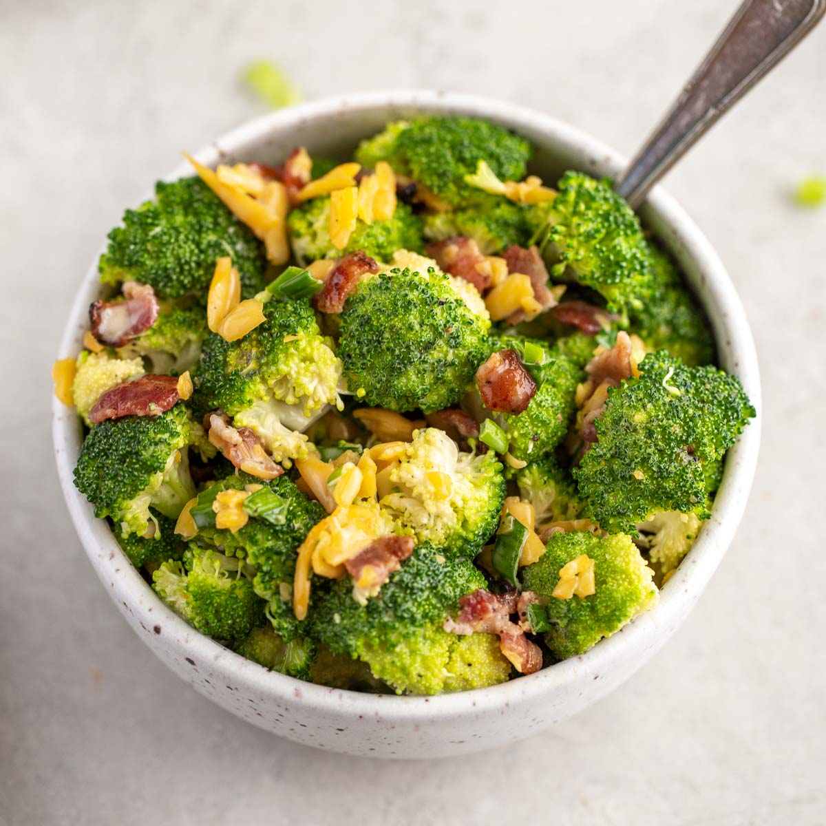 Broccoli salad in a speckled white bowl.