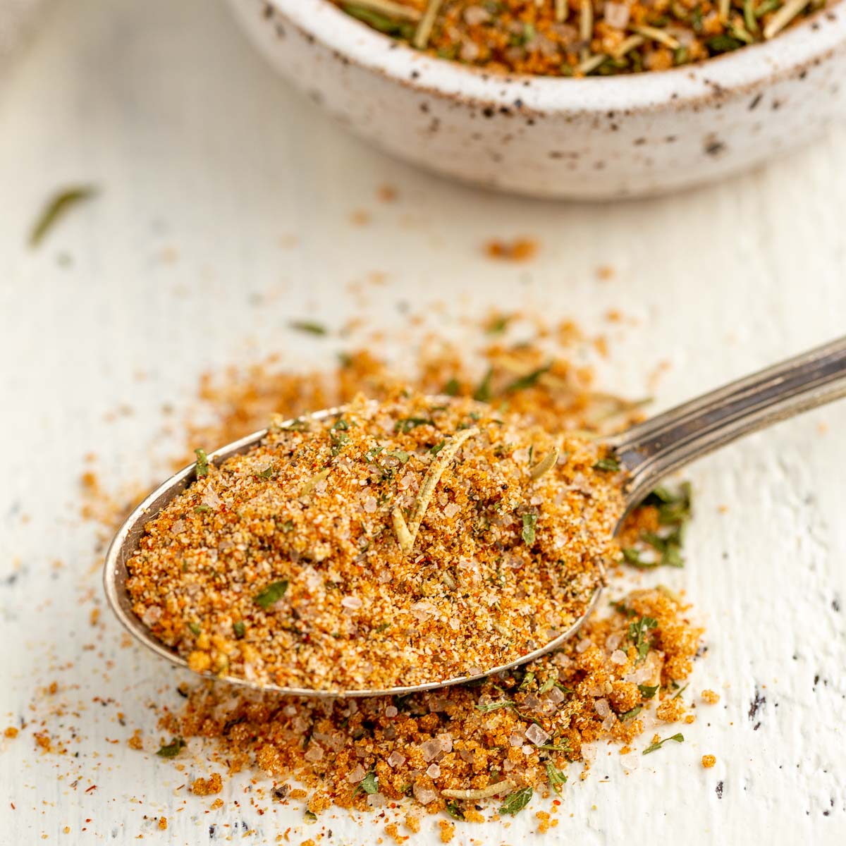 A spoon overflowing with with chicken rub.