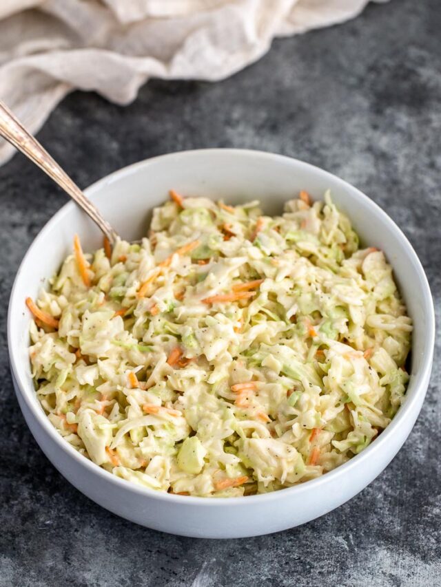 A large bowl filled with coleslaw that has been mixed with the dressing and is ready to be served.