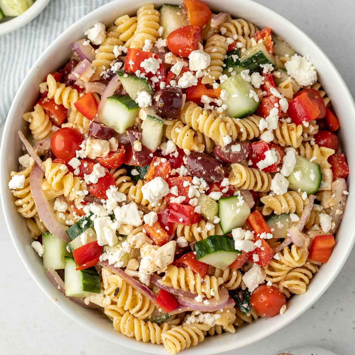 Pasta salad in a white bowl ready to be served.